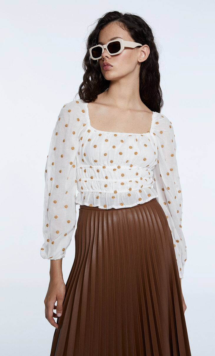 Cotton polka dot blouse with elastic detail.