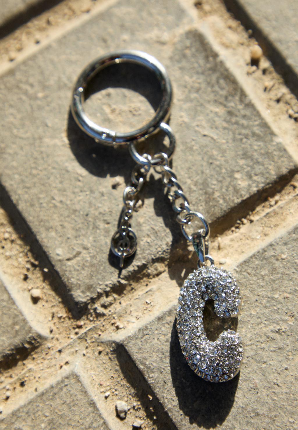 Key ring featuring an initial charm with rhinestones