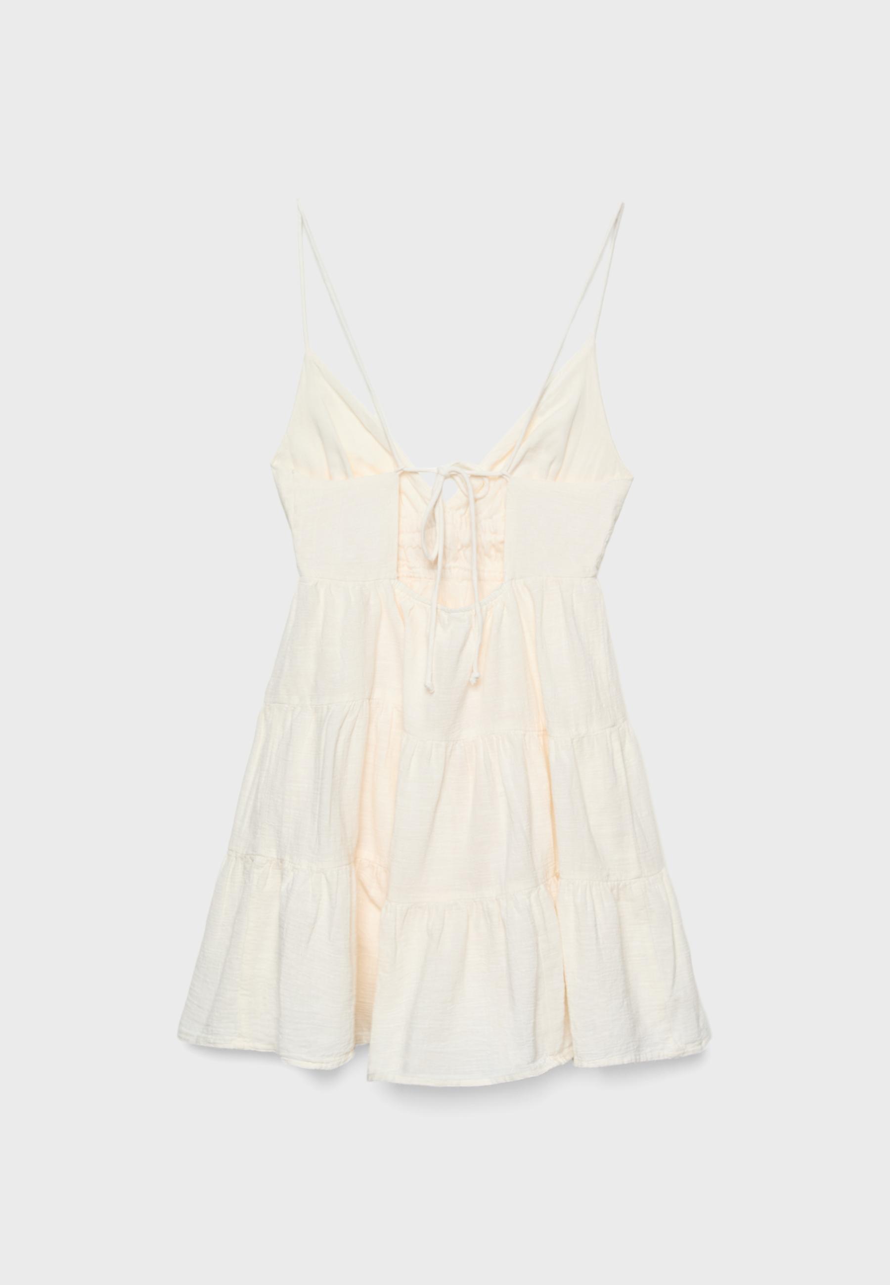 Arkası bağcıklı dökümlü kısa elbise