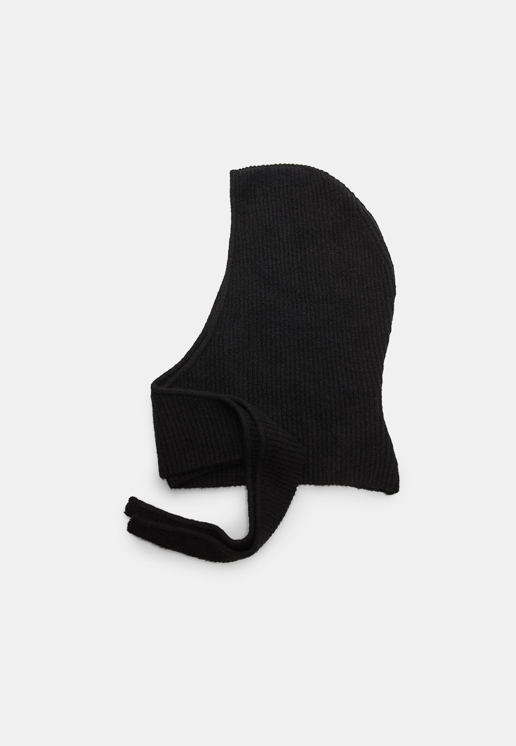 Side view of a basic black knitted balaclava with a fitted design and long straps.