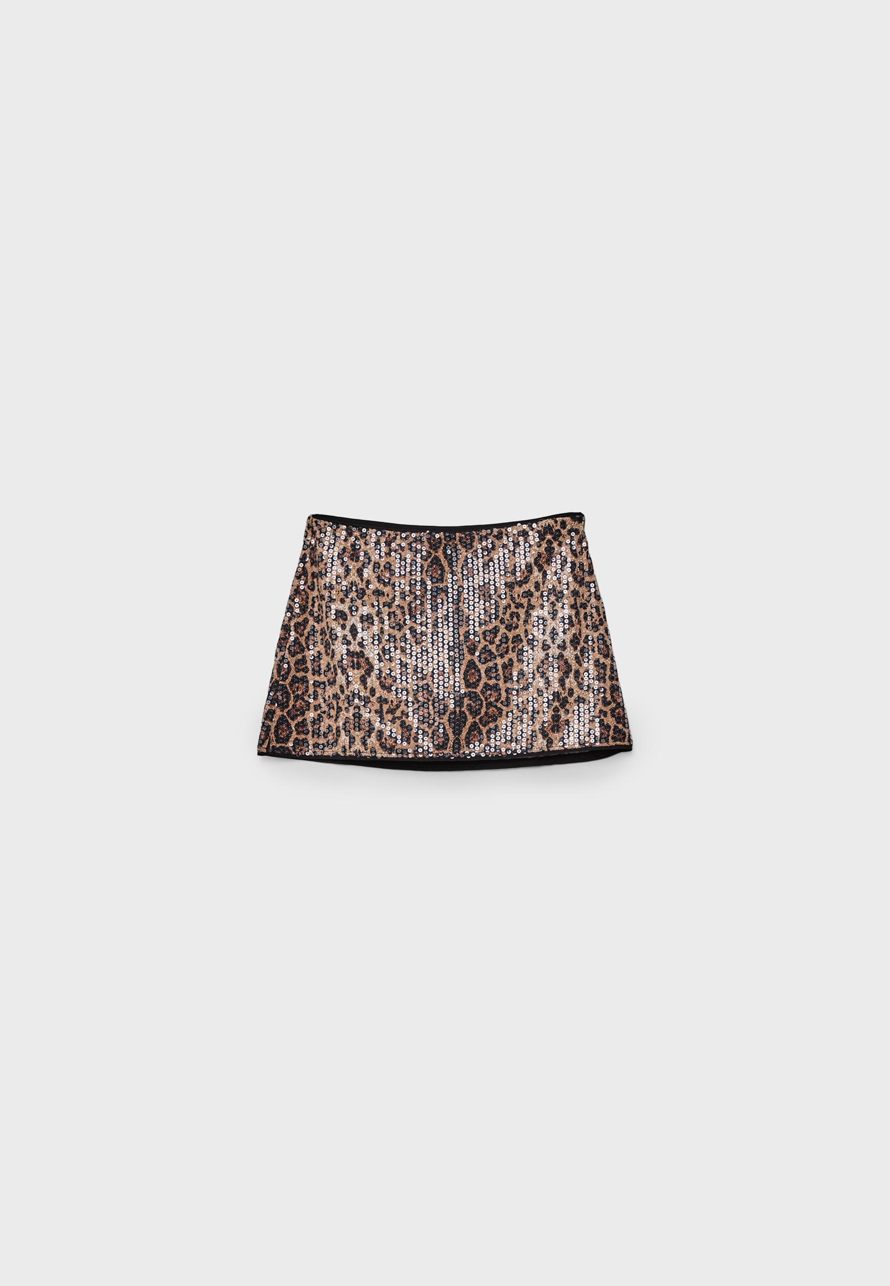 Front view of a beige mini skort with animal print and sequins, elastic waistband, and contrasting trim at the hem.